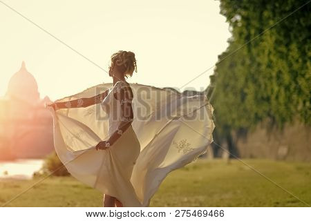 Back View Of Pretty Lovely Blond Bride In Long White Wedding Dress With Train Spinning Outdoor Sunny