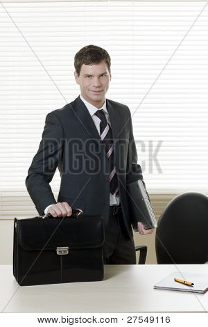 Businessman in his office with briefcase