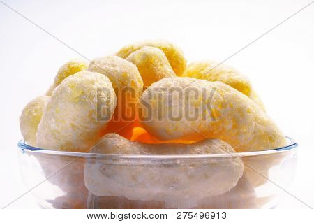 Yellow Corn Puffs In A Glass Bowl. Crunchy Flavored Puffed Snacks. Party, Movie, Tv, Game Snacks.