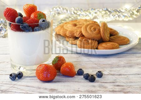 Panakota With Berries In A Glass, Biscuits Lying On A Wooden Table