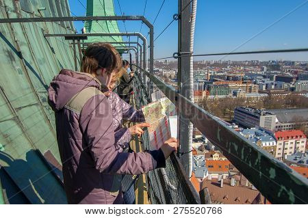 Tallinn, Estonia, 02 May 2017. Tourists View The Map On The Observation Deck Of The Church Of Olevis