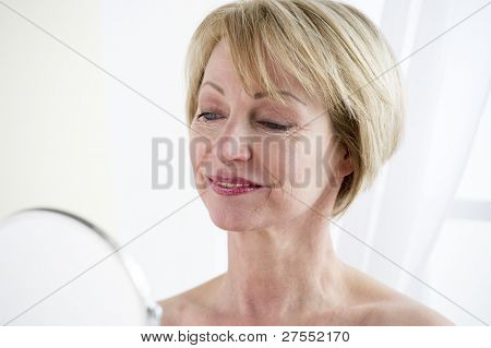 Beautiful mature woman making up
