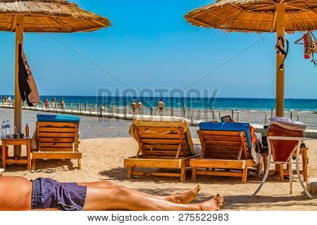 View Of The Beach And Vacationers In Loungers On The Shores Of The Red Sea Sunburn In The Sun On Vac