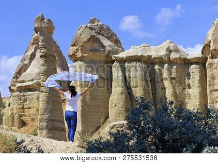 A Young Woman Is Holding A Motley Blue Veil Over Her Head, Standing In The Wind Between Huge And Old