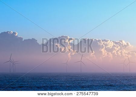 Clean Energy. Misty Morning Wind Turbines With Low Cloud Bank On The Sea Horizon. Beautiful Soft Env