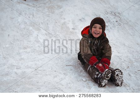 Sincere Children's Emotions. Сhild Ride Down A Snow Hill In Winter. Winter Fun Sliding Down (concept