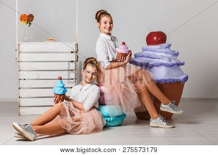 Beautiful Teenage Girls In Pink Tutu Skirts With Lollipops And Macaroons And Fansy Cakes In Studio O