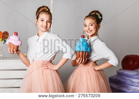 Beautiful Teenage Girls In Pink Tutu Skirts With Lollipops And Macaroons And Fansy Cakes In Studio O