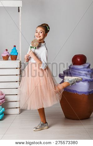 Beautiful Teenage Girls In Pink Tutu Skirts With Lollipops And Macaroons And Fansy Cakes In Studio O