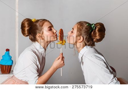 Beautiful Teenage Girls In Pink Tutu Skirts With Lollipops And Macaroons And Fansy Cakes In Studio O