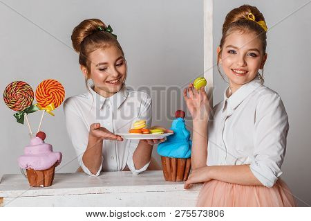 Beautiful Teenage Girls In Pink Tutu Skirts With Lollipops And Macaroons And Fansy Cakes In Studio O