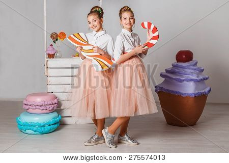 Beautiful Teenage Girls In Pink Tutu Skirts With Lollipops And Macaroons And Fansy Cakes In Studio O