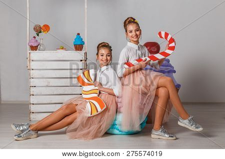 Beautiful Teenage Girls In Pink Tutu Skirts With Lollipops And Macaroons And Fansy Cakes In Studio O