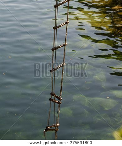 The Ladder Of Success Is Never Crowded At The Top. Rope Ladder With Wooden Steps. Rope Over Water Su