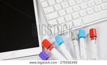 Medicine Bottles For Samples Next To Computer Tablet And Computer Keyboard In Medicine, Closeup On W