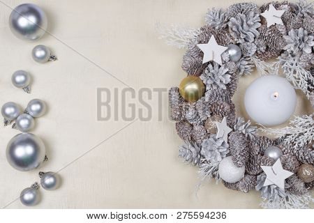 Beautiful Silver Christmas Wreath Decorated With Candle, Cones, Stars And Baubles And Presents On Wo