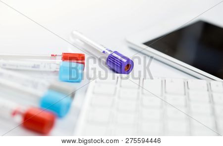 Medicine Bottles For Samples Next To Computer Tablet And Computer Keyboard In Medicine, Closeup On W