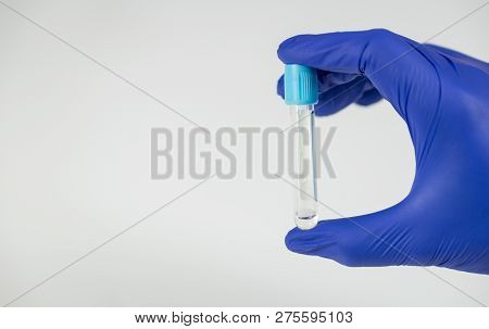 Hand Of A Doctor Holding A Bottle For Samples.