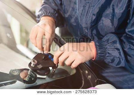 Close-up Of A Professional Windshield Repairman Working With Hydraulic Polymer Crack Filler. Elimina