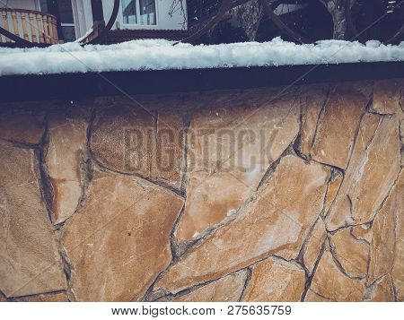 Srone Gate With Decorative Steel Trim. Snowfall On The Street.noon.
