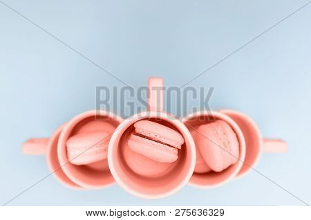 Macaroons In A Cup Of Trendy Coral Color On A Blue Background. There Is A Place For Text.