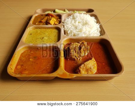 Indian Chicken Thali With Rice Dal Chicken Salad Vegetable Curry On A Plastic Segmented Plate In Woo
