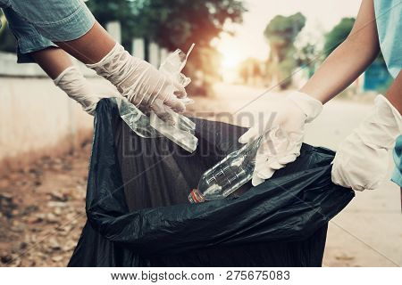 Mother And Child Help Picking Up Trash At Park