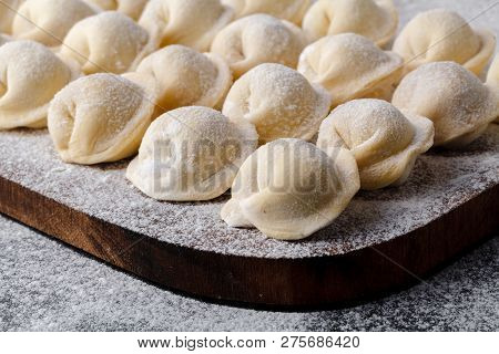 Uncooked Russian Pelmeni On Cutting Board And Ingredients For Homemade Pelmeni On White Table. Proce