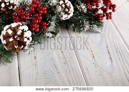 Spruce Branches, Cones And Red Berries On A White Wooden Background. Background For Christmas And Ne