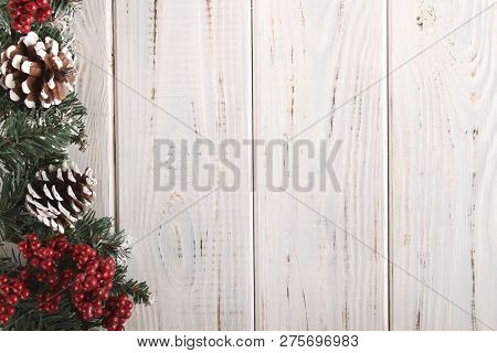 Spruce Branches, Cones And Red Berries On A White Wooden Background. Background For Christmas And Ne