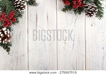 Spruce Branches, Cones And Red Berries On A White Wooden Background. Background For Christmas And Ne