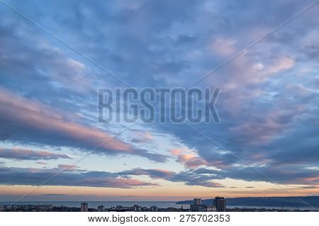 The Picturesque Sunset Sky With Blue-orange Clouds. Winter Cityscape And Urban Skyline At Sunset Tim