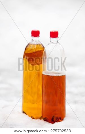 Two Plastic Beer One Litre Bottles Full And Half With Red Caps O