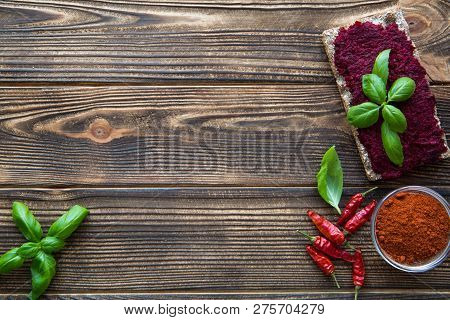 Beetroot Vegeratian Hummus With Red Paprika And Green Basil Leaves On Brown Wooden Rustic Table. Cop
