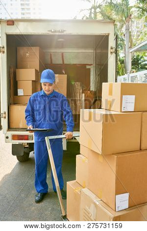 Young Vietnamse Courier Loading His Van For Delivery