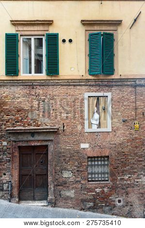 Siena, Italy - October 02, 2018: Sculpture Of Woman At The Window, Sculpture Of Woman At The Window,