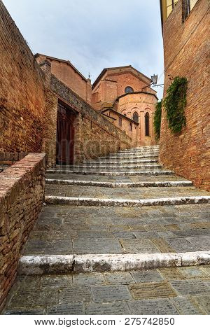 Stairs On The Street Via Val Di Montone And Basilica Santa Maria Dei Servi In Old City Siena. Italy