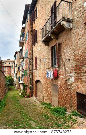 Medieval Narrow Street Vicolo Di Pulcetino In Old City Siena, Tuscany, Italy.