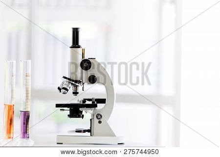 Coloful Teast Tube And Microscope On Table In Laboratory Room, Blurred Background, Concept For Labor