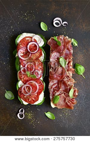 Italian Sandwith With Prosciutto Crudo, Mozzarella Cheese, Salami And Basil .top View With Copy Spac