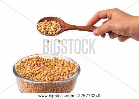 Spoon In Hand With Yellow Peas On White Background. Peas In Glass Bowl
