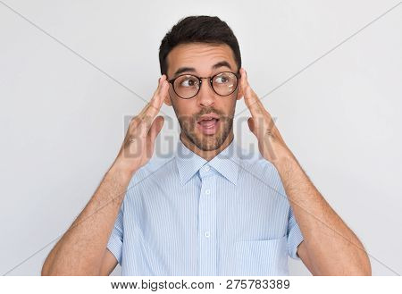 Surprised Handsome Young Male Touch His Glasses And Opens Mouth With Amazed Expression, Looking Asid