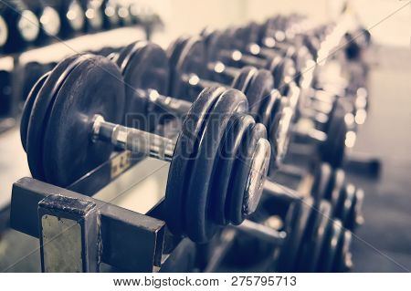 Rows Of Dumbbells In The Gym With Hign Contrast And Monochrome Color Tone. Concept Of Bodybuilding.