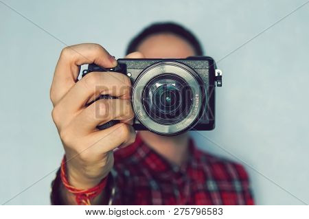 Male Photographer Hold Camera In His Hands. Mirrorless Camera Close Up In The Hand Of A Young Man On