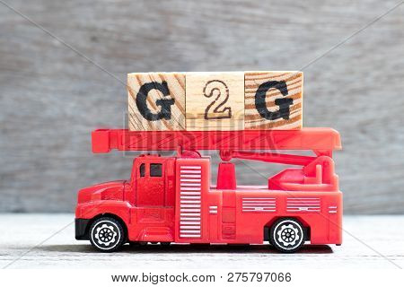 Toy Fire Ladder Truck Hold Letter Block In Word G2g (government To Government) On Wood Background