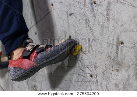 Rocky Shoe On A Tiny, Scanty Snare Stands With The Tip Of The Sock In Close-up On The Climbing Wall 