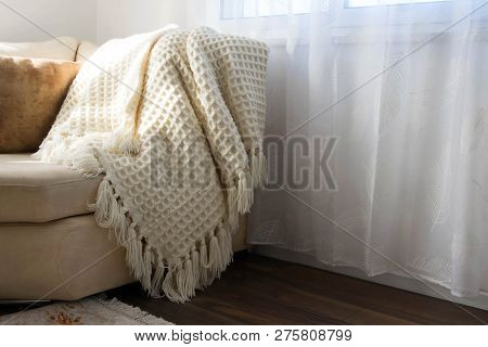 Stylish Brightly Interior Of Living Room. Inviting Comfortable Sofa With Handmade Woolen Blanket. Co