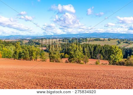 Typical Red Soil Of Countryside Around Nova Paka. Agricultural Landscape With Giant Mountains On The