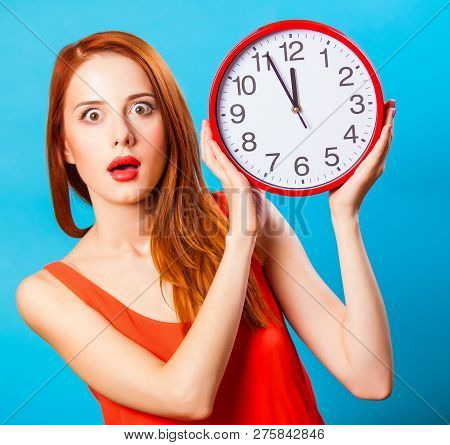 Redhead Girl With Huge Clock On Blue Background.