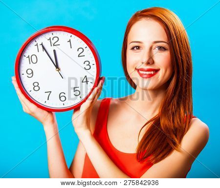 Redhead Girl With Huge Clock On Blue Background.